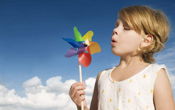 女孩用力氣吹動(dòng)風(fēng)車(chē)